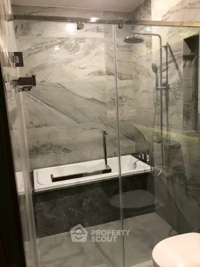 Luxurious modern bathroom with elegant marble tiles and sleek shower design.