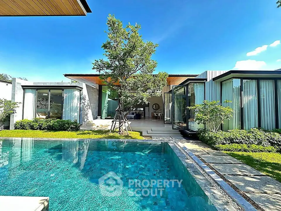 Luxurious modern villa with stunning pool and lush garden, perfect for serene living.