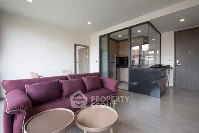 Modern open-plan living room with stylish kitchen and cozy purple sofa