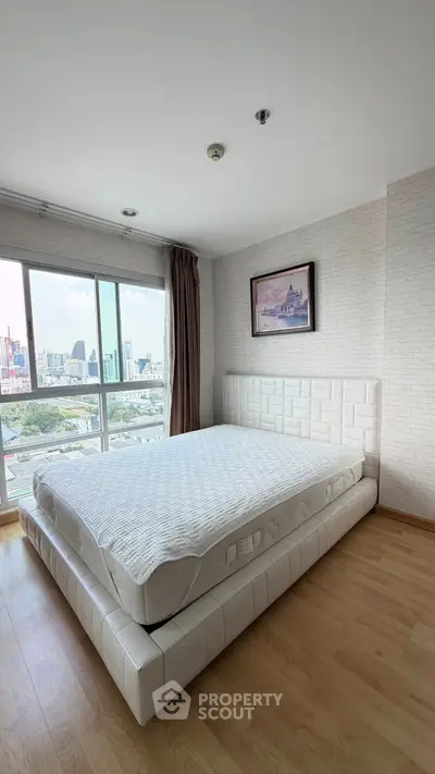 Spacious bedroom with city view and modern decor in high-rise apartment
