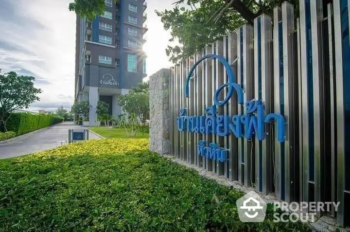 Modern residential building with lush greenery and stylish entrance signage.