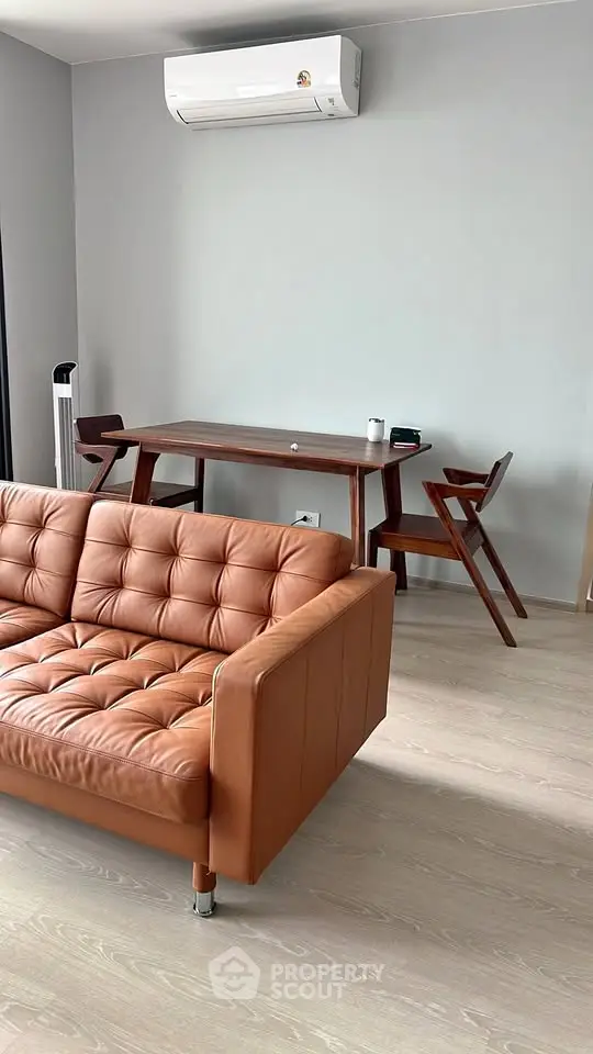 Modern living room with stylish leather sofa and wooden dining set