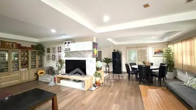 Spacious living room with modern decor and open layout, featuring a cozy dining area and stylish furnishings.