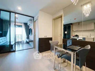 Modern apartment interior with open living and dining area, featuring sleek furniture and a glass partition.