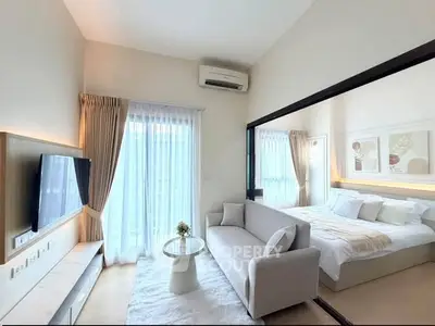 Modern studio apartment with open layout, featuring cozy living area and stylish bedroom.