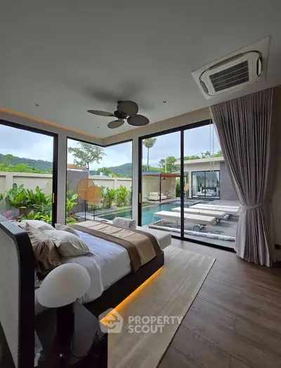 Luxurious bedroom with pool view and modern decor in a tropical setting, featuring large windows and elegant furnishings.