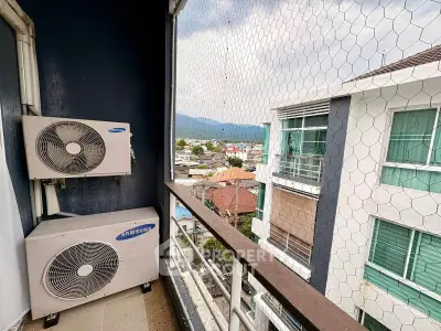High-rise balcony with air conditioning units and city view