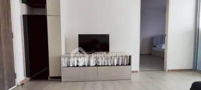 Modern living room with sleek TV stand and glimpse of cozy bedroom