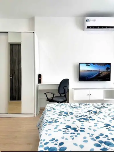 Modern bedroom with stylish decor, featuring a sleek desk, comfortable chair, and wall-mounted TV.