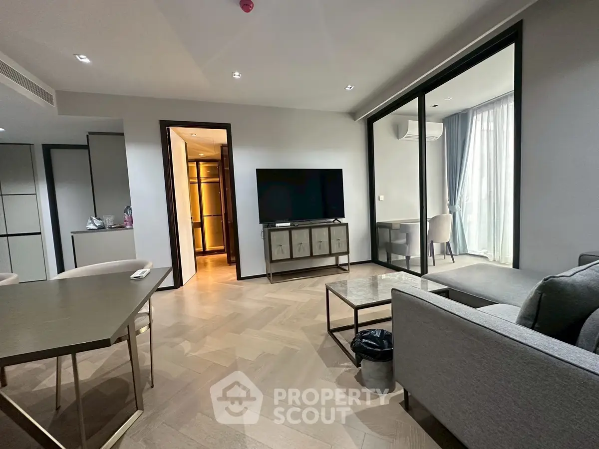 Modern living room with sleek furniture and large TV, featuring a stylish open layout and natural light.