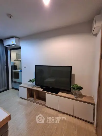 Modern living room with sleek TV setup and stylish decor in a cozy apartment.