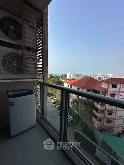 Charming balcony with city and sea view, featuring air conditioning units and a washing machine.
