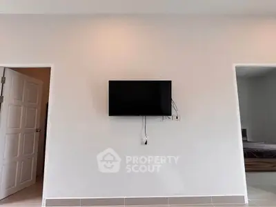Minimalist living room with wall-mounted TV and open doorways