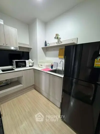 Modern kitchen with sleek appliances and stylish cabinetry in a contemporary apartment.
