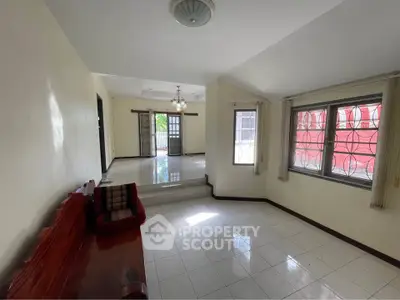 Spacious living room with elegant wooden furniture and large windows for natural light.