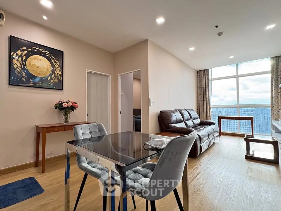 Modern living room with elegant decor and stunning city view from large windows.