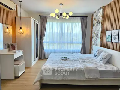Spacious modern bedroom with elegant decor and large window offering natural light.