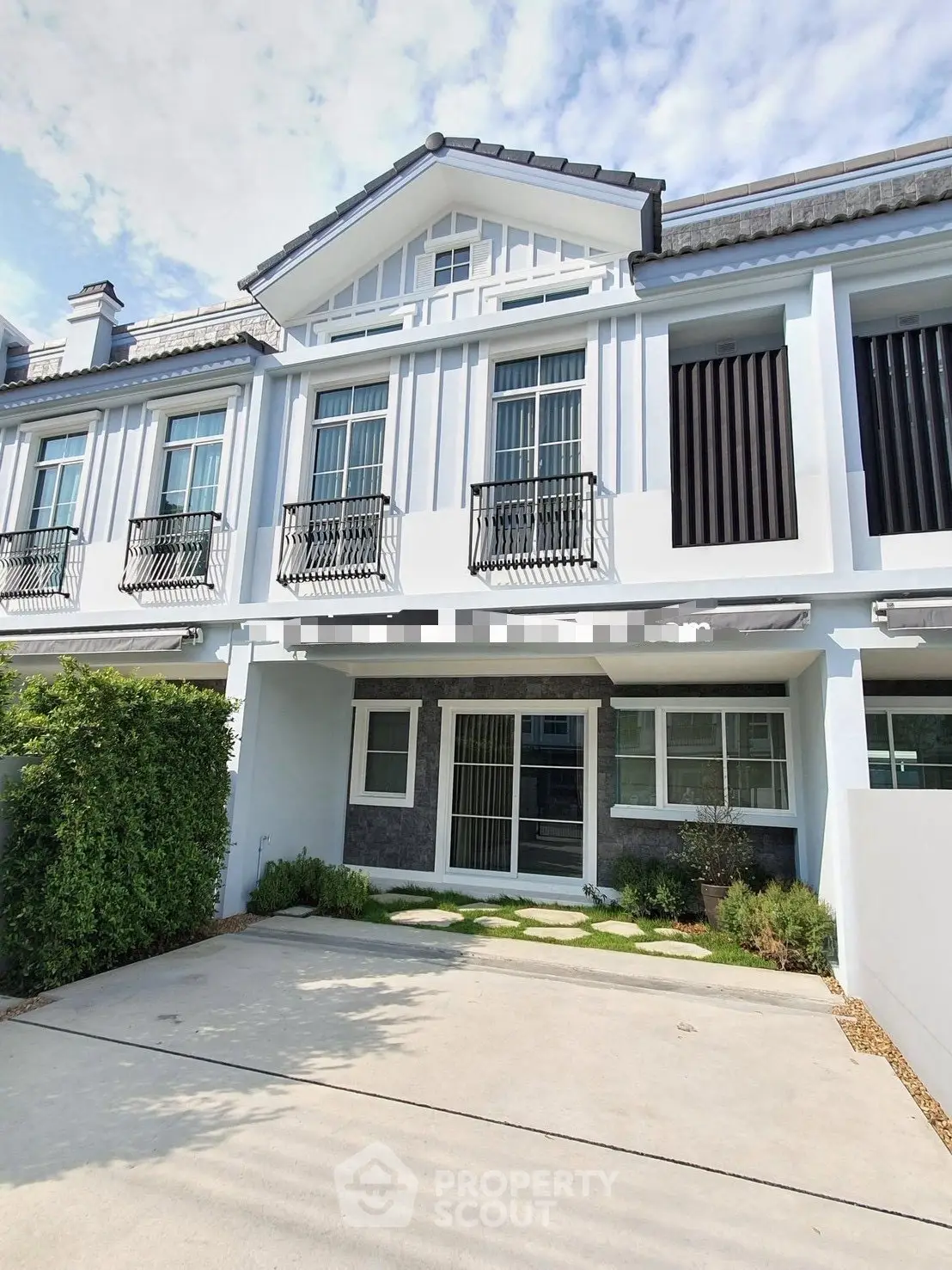 Charming townhouse with modern facade and spacious driveway in a serene neighborhood.