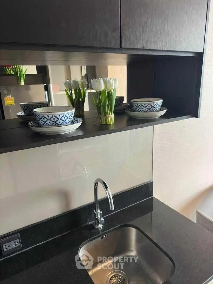 Modern kitchen with sleek black countertop and stylish dishware