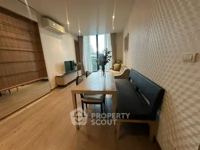 Modern living room with stylish decor and natural light, featuring a cozy dining area and elegant furnishings.