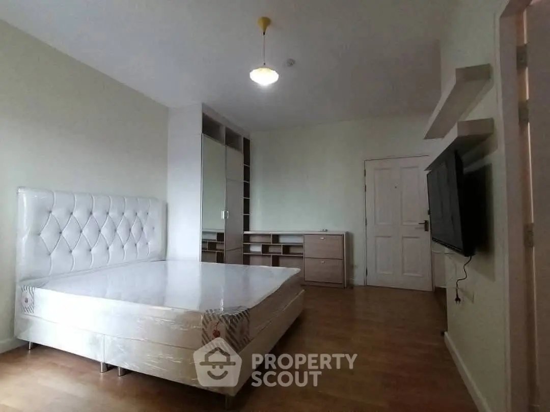 Spacious bedroom with modern furnishings and ample storage in a stylish apartment.