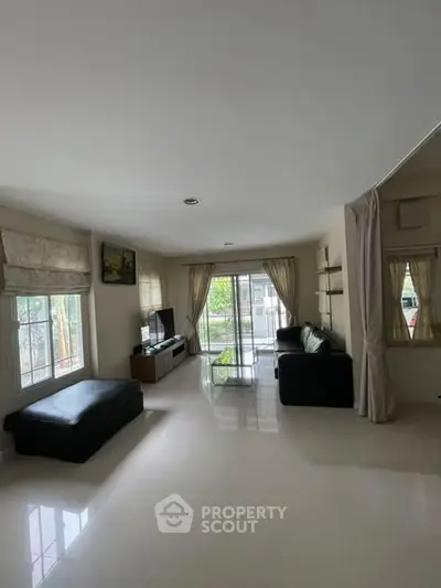 Spacious living room with modern decor and large windows for natural light.