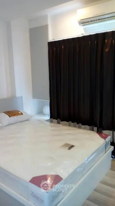 Modern bedroom with large window and air conditioning, featuring a comfortable bed and stylish curtains.