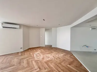Spacious modern living room with elegant herringbone flooring and air conditioning.