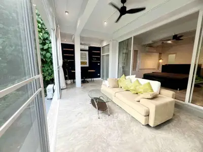 Spacious living room with modern decor and large windows overlooking greenery.