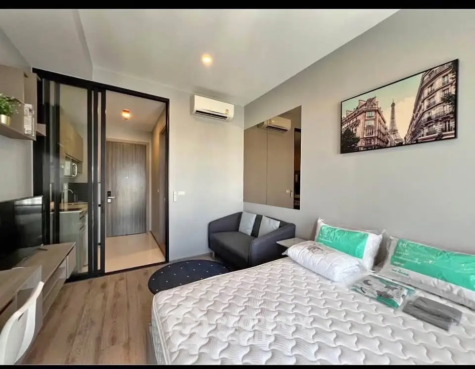 Modern bedroom with stylish decor and cozy seating area in a contemporary apartment.