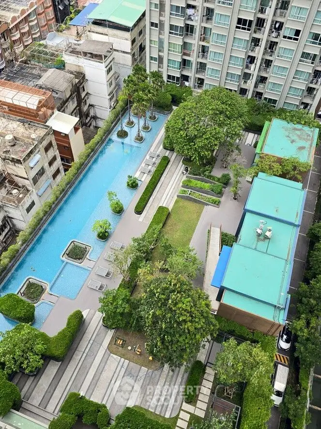 Stunning aerial view of modern apartment complex with lush garden and inviting swimming pool.