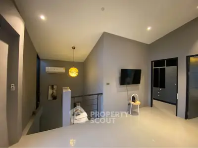 Modern interior with sleek design, featuring a wall-mounted TV and stylish lighting in a spacious living area.
