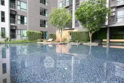 Modern apartment complex with serene pool and lush greenery