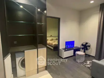 Modern living room with sleek storage and cozy bedroom view