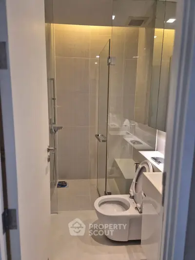 Modern bathroom with glass shower and sleek fixtures in a contemporary home.