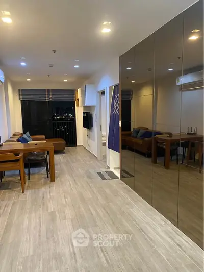 Modern living room with sleek design and city view, featuring stylish furniture and large windows.
