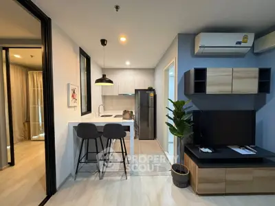 Modern open-plan living room with kitchen, featuring sleek furniture and stylish decor.