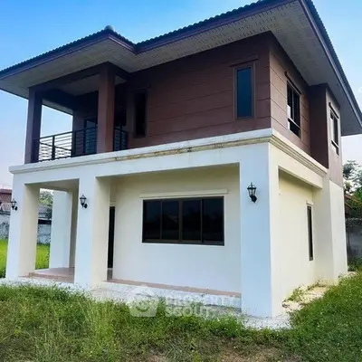 Modern two-story house with spacious balcony and large windows, surrounded by lush greenery.