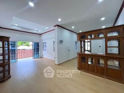 Spacious living room with elegant wooden cabinetry and large windows for natural light.