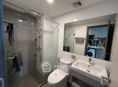 Modern bathroom with glass shower and sleek fixtures in a contemporary apartment.