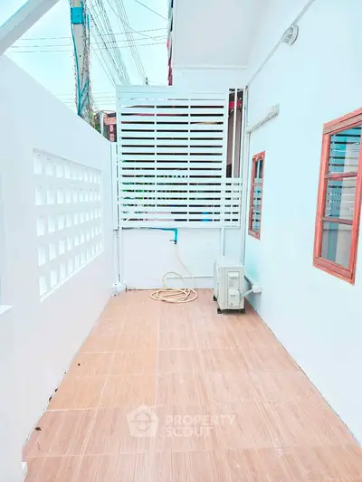 Charming outdoor space with tiled flooring and privacy screen, perfect for relaxation or small gatherings.