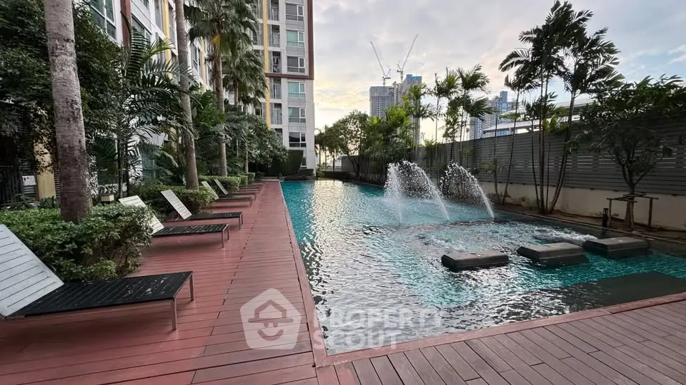 Luxurious condominium pool area with modern design and lush greenery, perfect for relaxation and leisure.