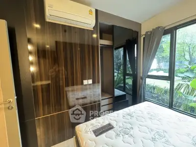 Modern bedroom with large window and air conditioning, featuring sleek wood paneling and a comfortable mattress.