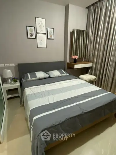 Cozy bedroom with modern decor and stylish furnishings in a well-lit apartment.