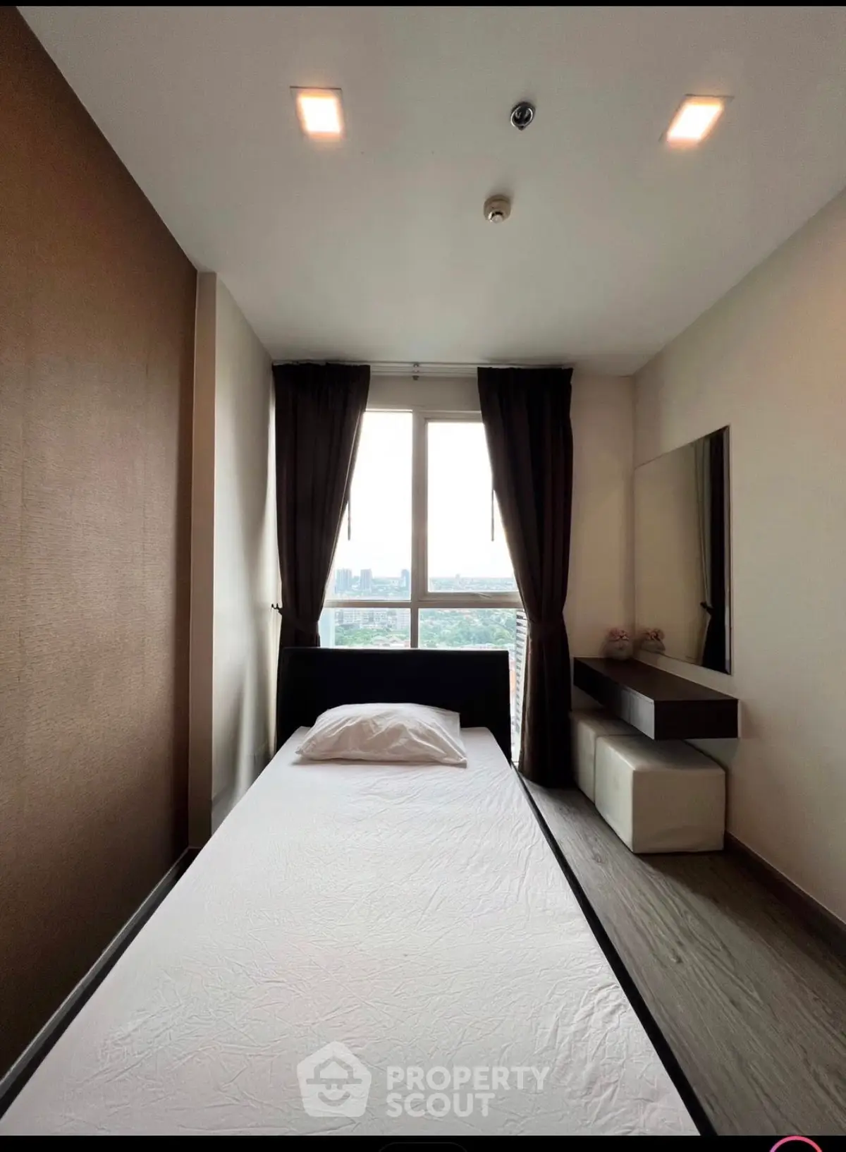 Modern minimalist bedroom with large window and sleek furnishings