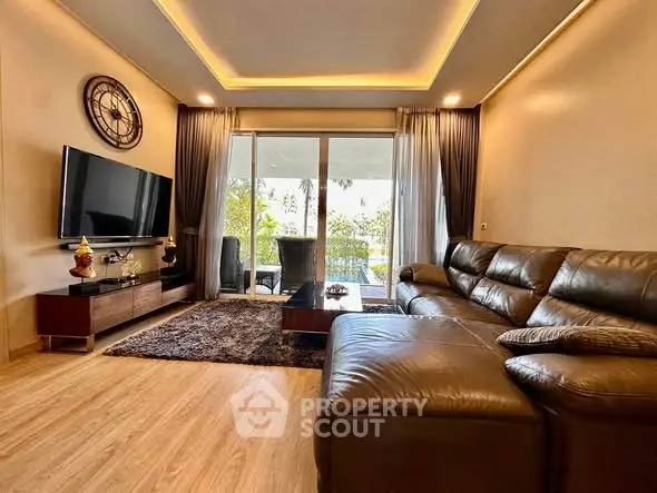 Luxurious living room with leather sofa and modern decor overlooking a scenic balcony view.