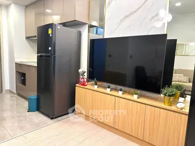 Modern living room with sleek TV unit and stainless steel fridge, perfect for contemporary urban living.
