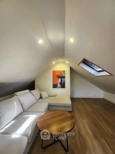 Stylish attic living room with modern decor and skylight