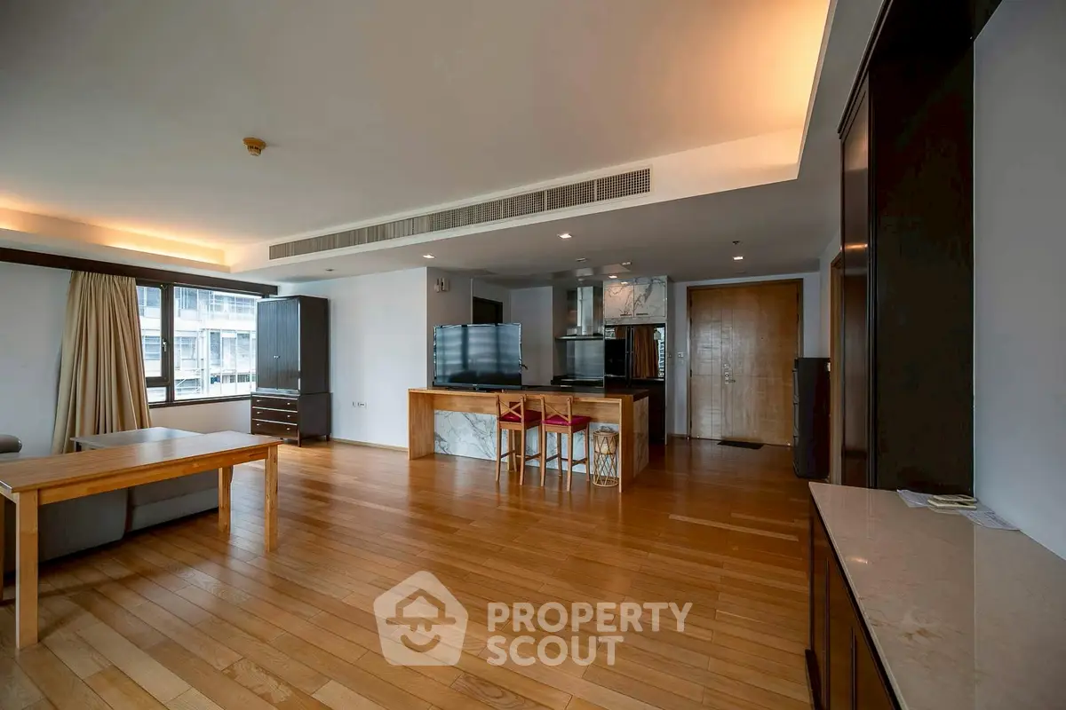 Spacious open-plan living room with modern kitchen and wooden flooring