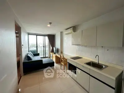 Modern open-layout living room with kitchen and balcony view